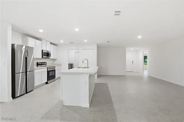 a kitchen with white cabinets and stainless steel appliances