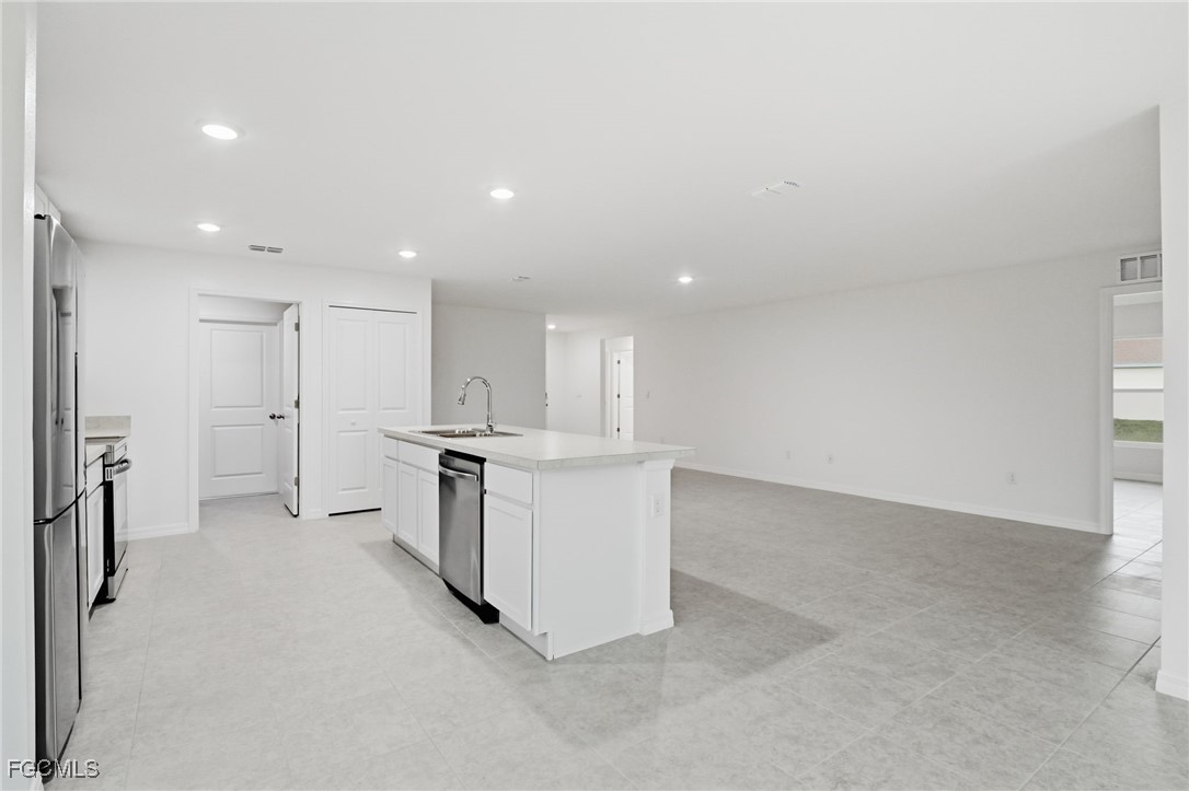 3418 20th Street Southwest Lehigh Acres, FL 33976 - Photo 8 of 34 an empty room with a kitchen and windows