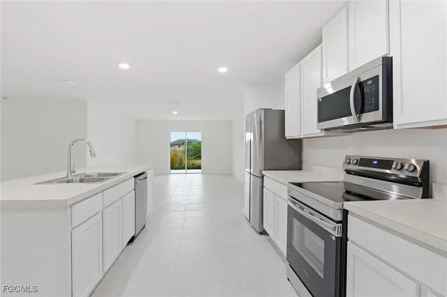 a kitchen with stainless steel appliances granite countertop a sink and a stove