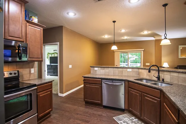a kitchen with granite countertop a refrigerator and a sink