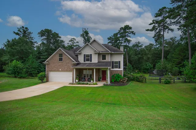 a front view of a house with a yard and potted plants
