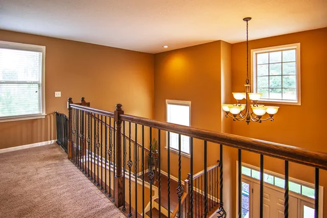 a view of a house with a yard and large tree