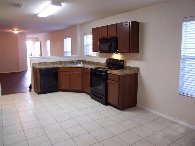 a kitchen with stainless steel appliances granite countertop a stove top oven a sink dishwasher and a microwave oven on the blue kitchen countertops