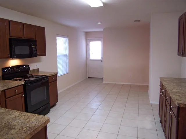 a kitchen with granite countertop a stove and a sink