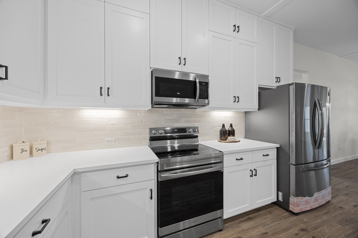 17701 Village Drive Dripping Springs, TX 78620 - Photo 13 of 36 a kitchen with stainless steel appliances white cabinets and a stove a refrigerator a sink