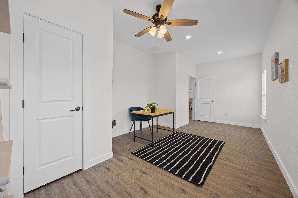 17701 Village Drive Dripping Springs, TX 78620 - Photo 25 of 36 a view of a livingroom with wooden floor and a ceiling fan