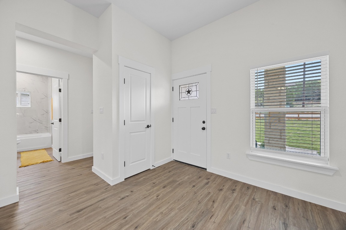 17701 Village Drive Dripping Springs, TX 78620 - Photo 3 of 36 a view of an empty room with wooden floor and a window