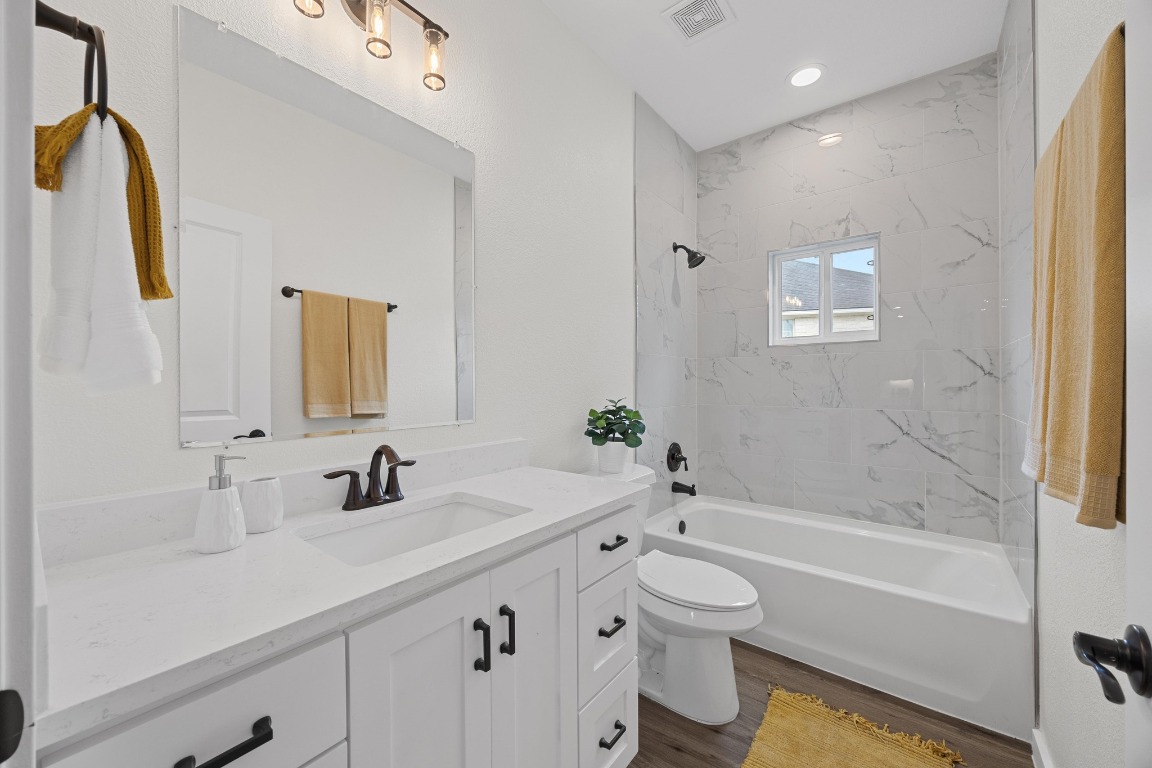 17701 Village Drive Dripping Springs, TX 78620 - Photo 31 of 36 a bathroom with a tub sink toilet and a mirror