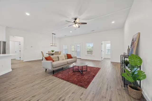 a living room with furniture hard wood floor and a chandelier