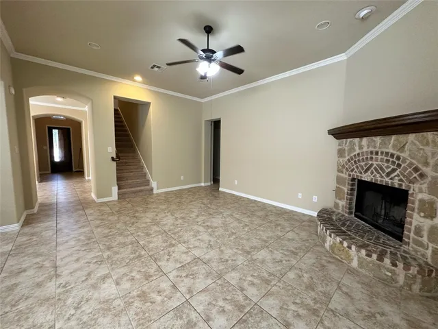 an empty room with fan and a fireplace