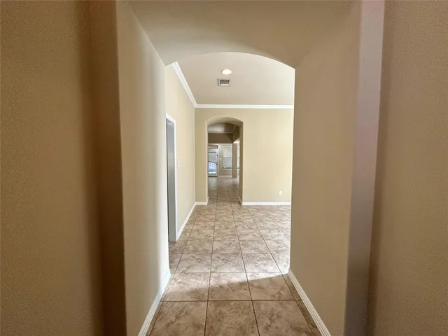 a view of a hallway with wooden floor and a living room