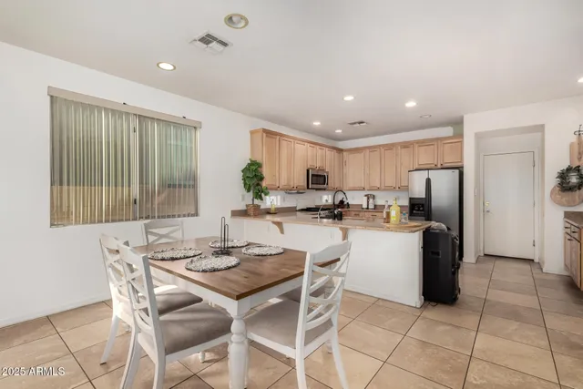 a kitchen with a refrigerator and a dining table