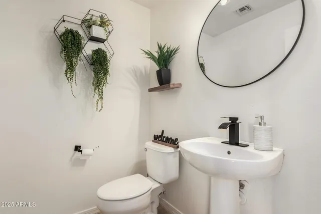 a bathroom with a sink mirror and toilet