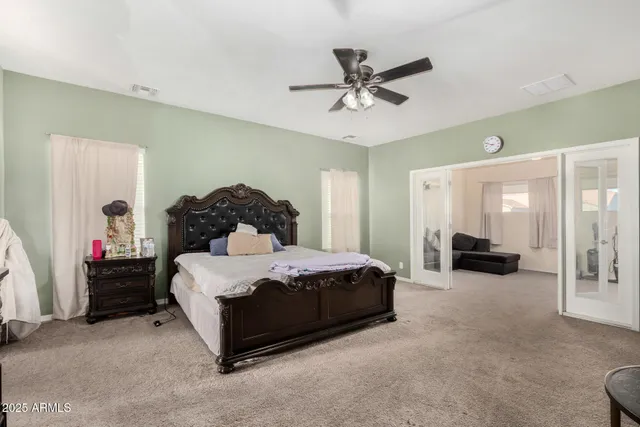 a spacious bedroom with a bed and a chandelier