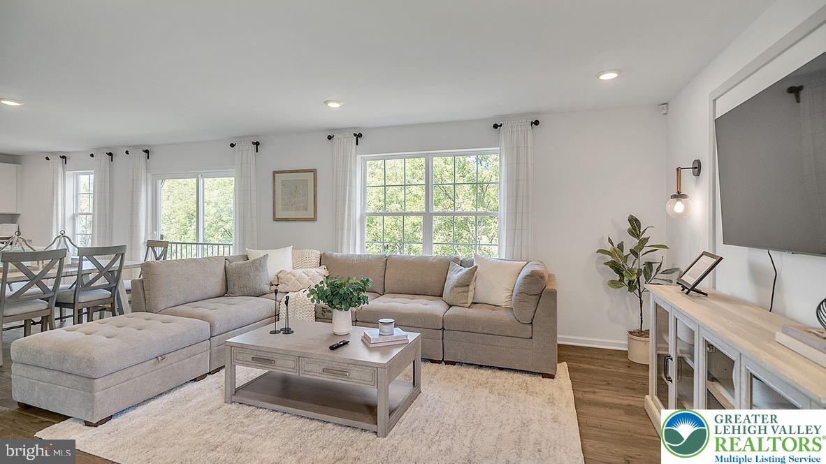 115 Winding Road Easton, PA 18040 - Photo 10 of 24 This living area offers a harmonious blend of comfortable seating and outdoor views, creating an inviting space for relaxation and gatherings.