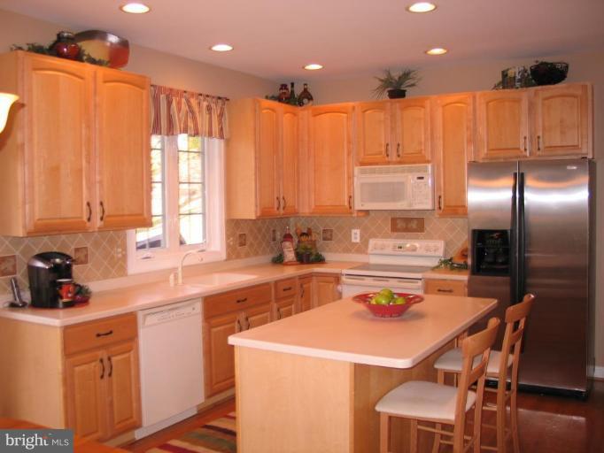 3648 Valley Road Ellicott City, MD 21042 - Photo 6 of 30 a kitchen with a table chairs refrigerator and cabinets