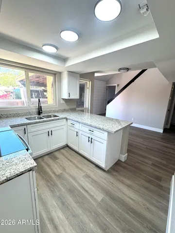 a large kitchen with stainless steel appliances granite countertop a sink and dishwasher a stove with wooden floor