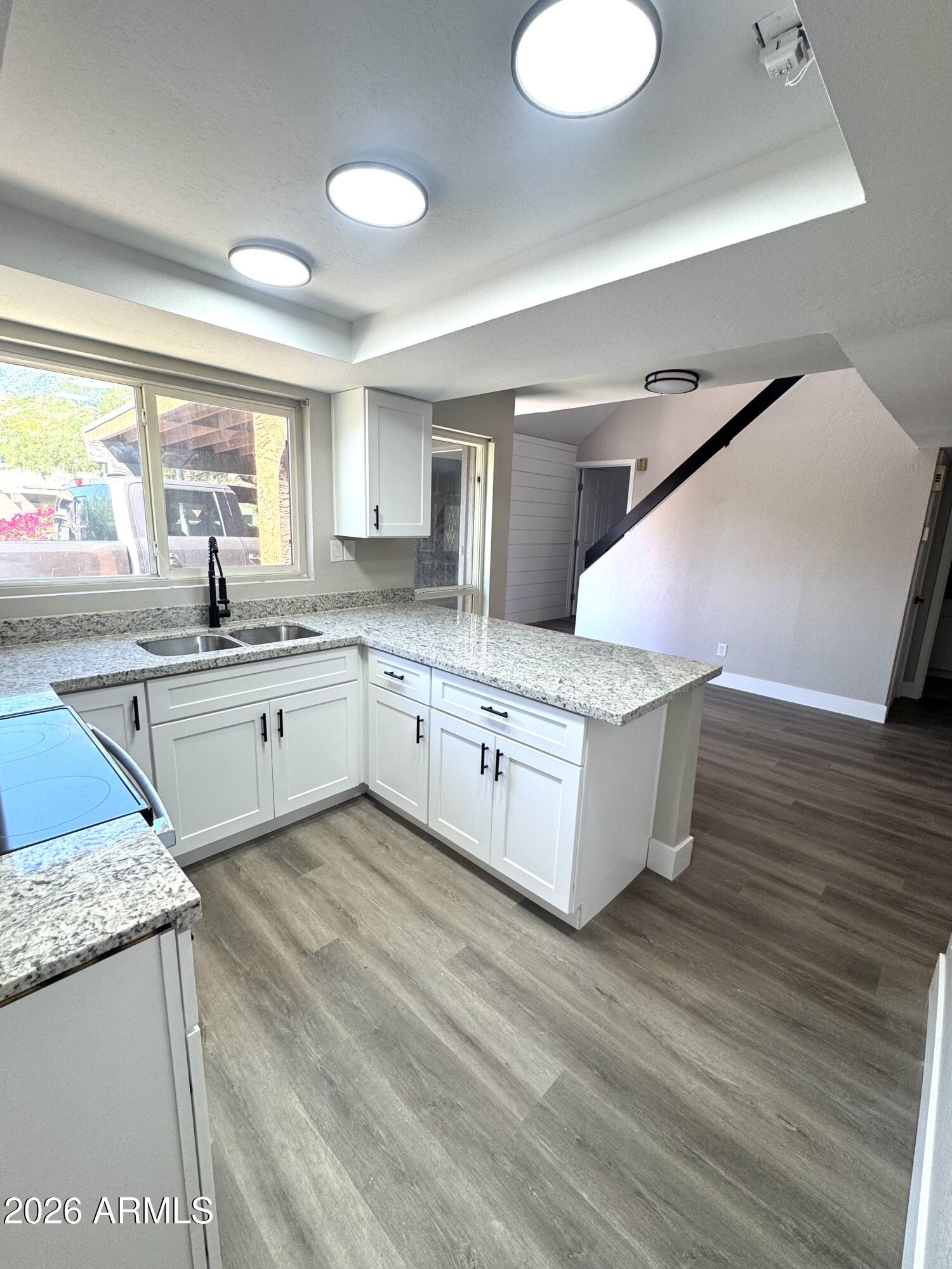 2003 North 51st Way Phoenix, AZ 85008 - Photo 1 of 22 a large kitchen with stainless steel appliances granite countertop a sink and dishwasher a stove with wooden floor
