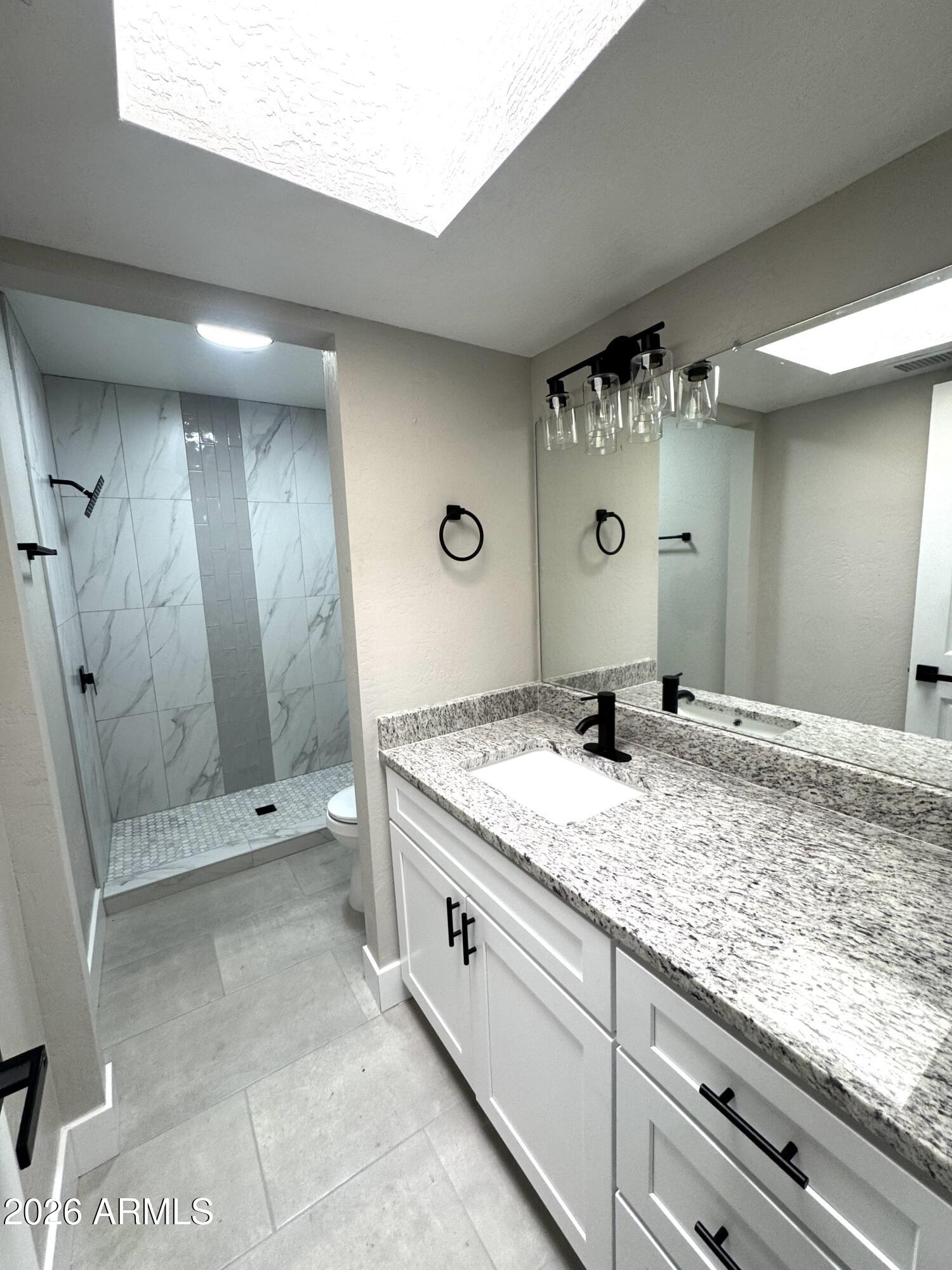 2003 North 51st Way Phoenix, AZ 85008 - Photo 19 of 22 a bathroom with a granite countertop sink a mirror and a shower