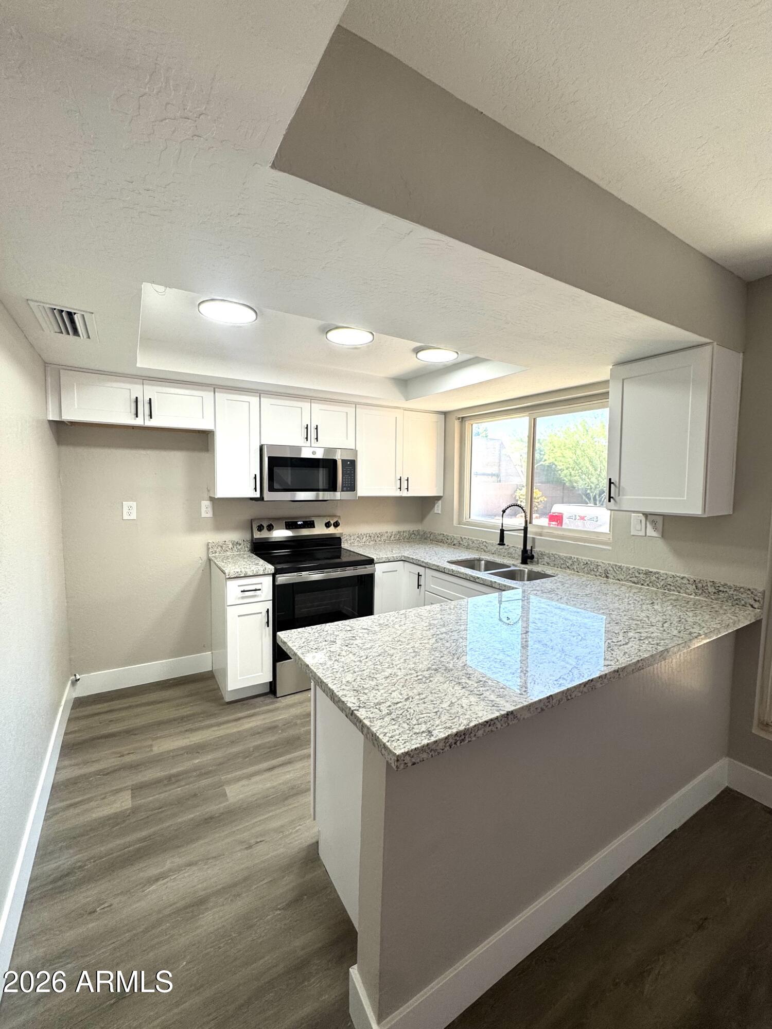 2003 North 51st Way Phoenix, AZ 85008 - Photo 2 of 22 a large kitchen with granite countertop a large counter top stainless steel appliances and cabinets