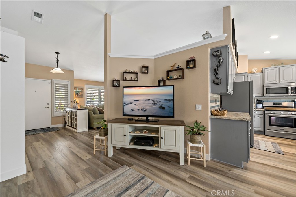 31141 Vía Gilberto Temecula, CA 92592 - Photo 13 of 39 a living room with furniture a fireplace and kitchen view