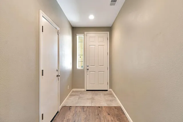 a view of a hallway with wooden floor and closet