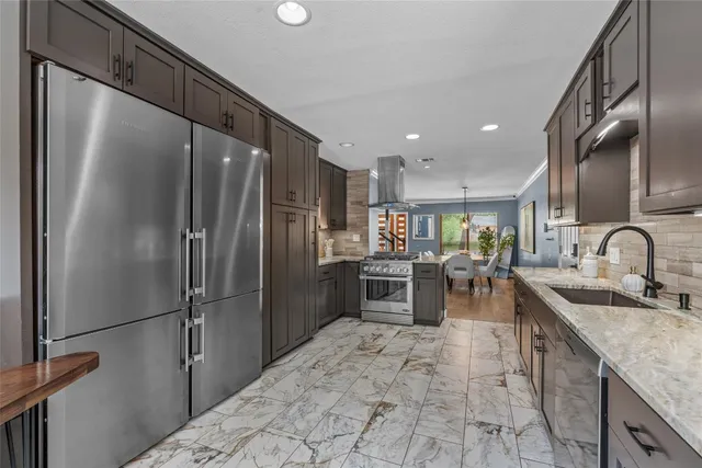 a kitchen with granite countertop a refrigerator and a sink
