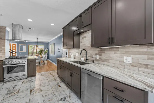 a kitchen with stainless steel appliances granite countertop a sink stove and cabinets