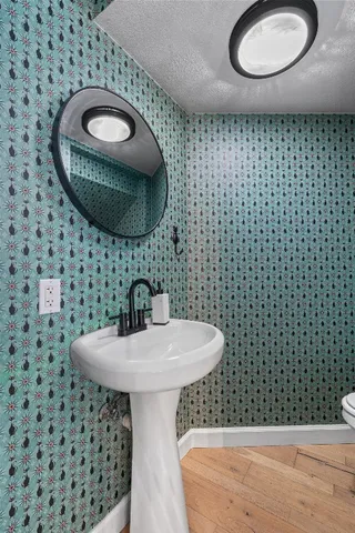 a bathroom with a sink a toilet and a mirror