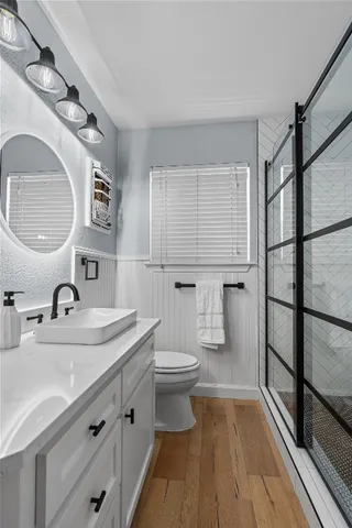 a bathroom with a sink a toilet and shower