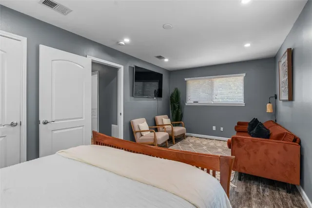 a bedroom with a bed and wooden floor