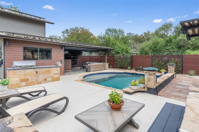 a view of a patio with couches table and chairs with wooden floor and fence