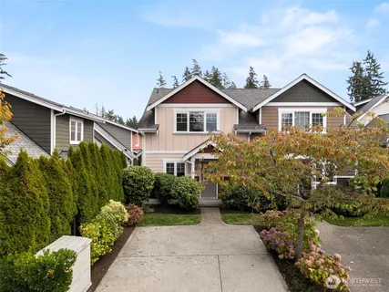 a front view of a house with a yard and potted plants