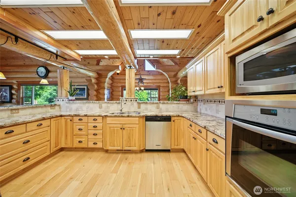 a large kitchen with stainless steel appliances granite countertop a stove and a sink
