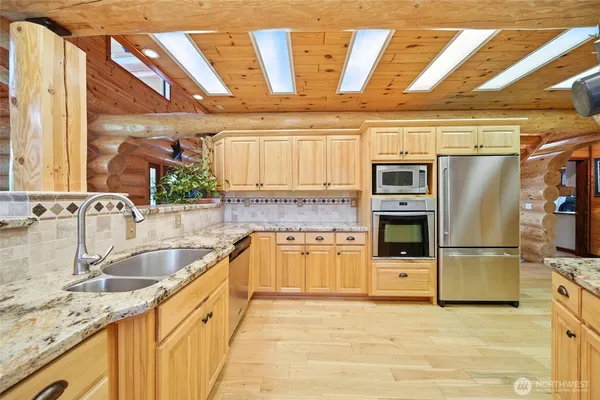 a kitchen with stainless steel appliances granite countertop a sink a stove and a refrigerator