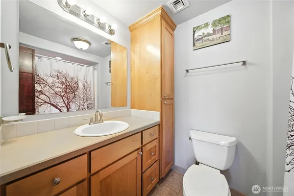 a bathroom with a toilet sink and mirror