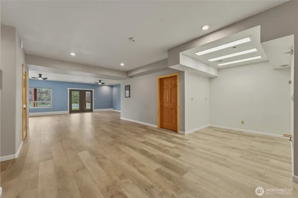 a view of an empty room with window and wooden floor