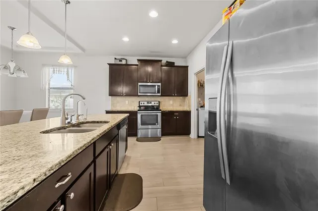 a kitchen with stainless steel appliances granite countertop a sink stove and refrigerator