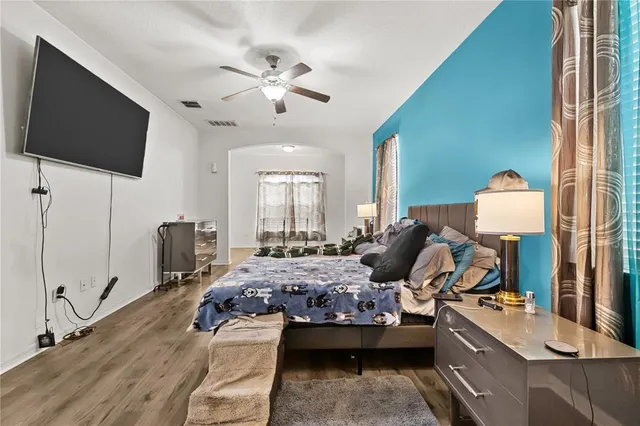 a bedroom with a bed and wooden floor