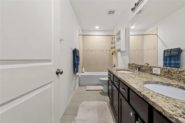 a bathroom with a granite countertop sink mirror and a bathtub