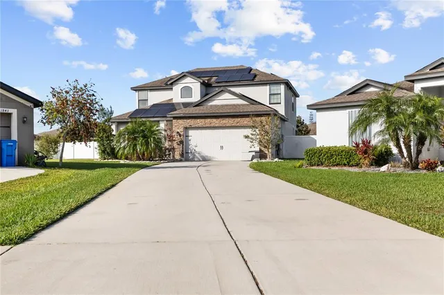 a front view of a house with a yard and trees