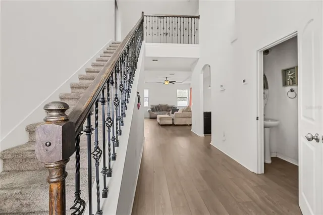 a view of a hallway with wooden floor and staircase