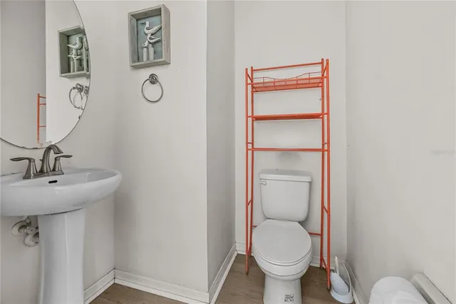 a bathroom with a toilet a sink and mirror