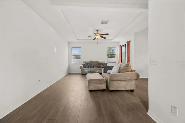 a living room with furniture and a ceiling fan
