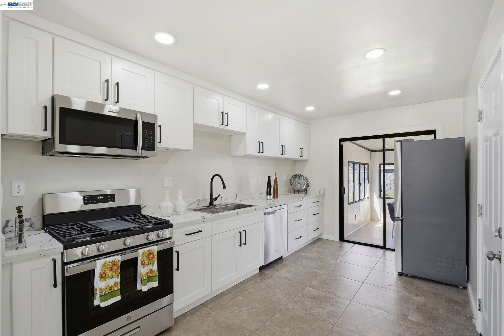 937 Neil Way Hayward, CA 94545 - Photo 13 of 37 a kitchen with stainless steel appliances a stove a sink and a microwave