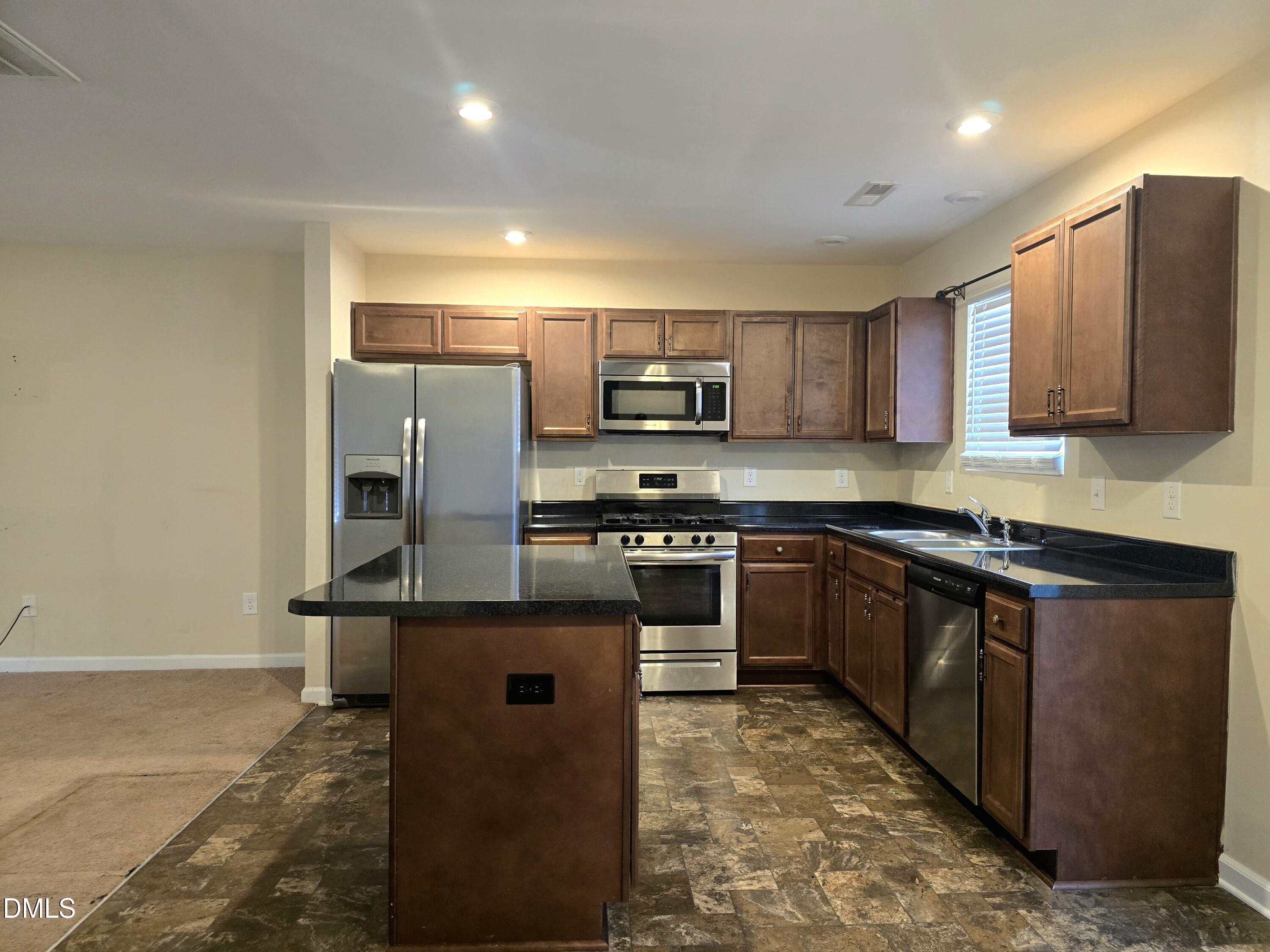 202 Mason Road Durham, NC 27712 - Photo 3 of 15 a kitchen with stainless steel appliances granite countertop a stove a sink and a refrigerator