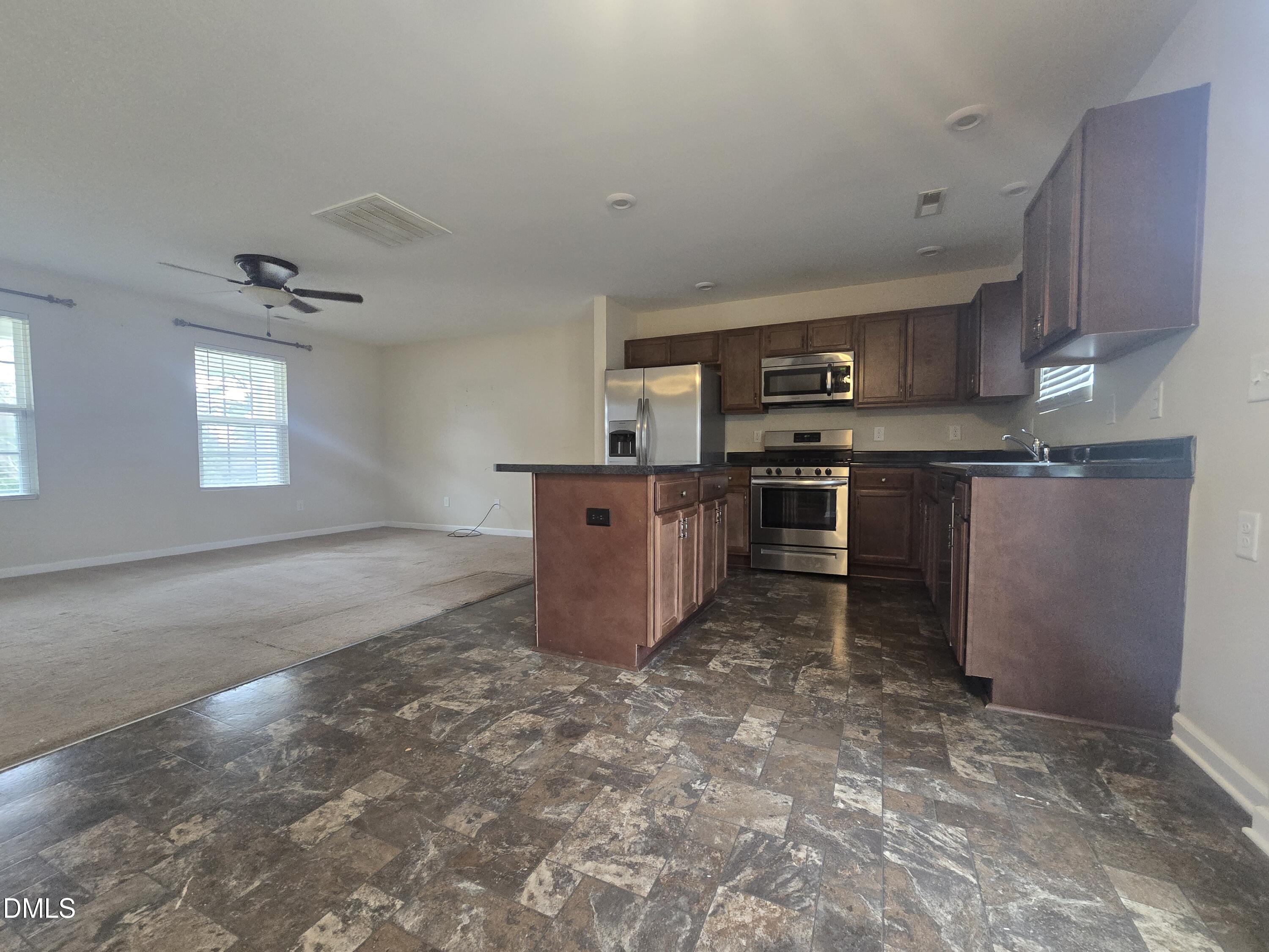 202 Mason Road Durham, NC 27712 - Photo 5 of 15 a kitchen with stainless steel appliances granite countertop a stove top oven a sink a counter space and cabinets