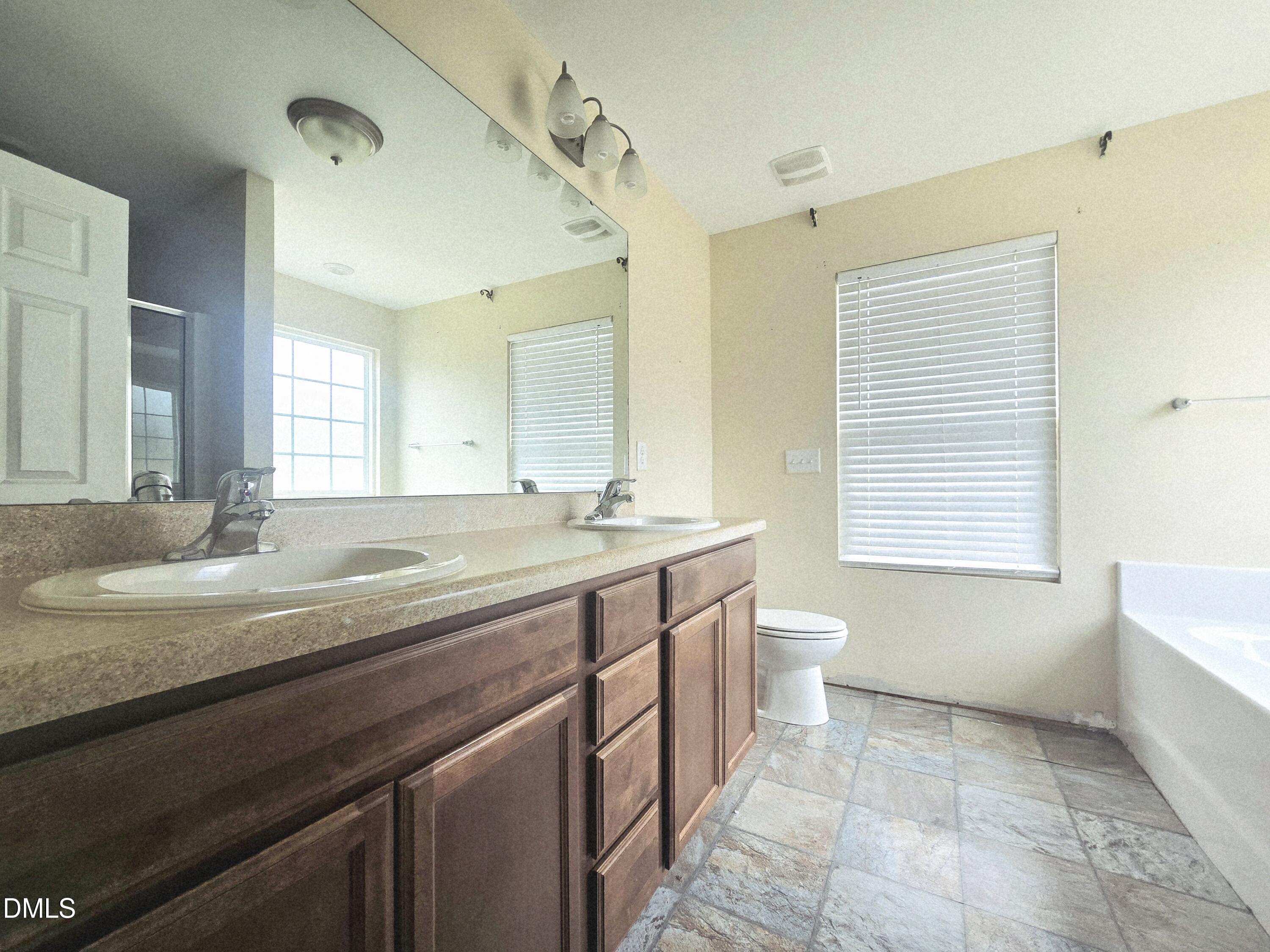 202 Mason Road Durham, NC 27712 - Photo 7 of 15 a bathroom with a granite countertop sink a toilet and a bathtub