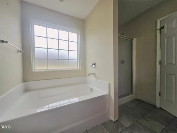 a white bath tub sitting in a bathroom next to a window