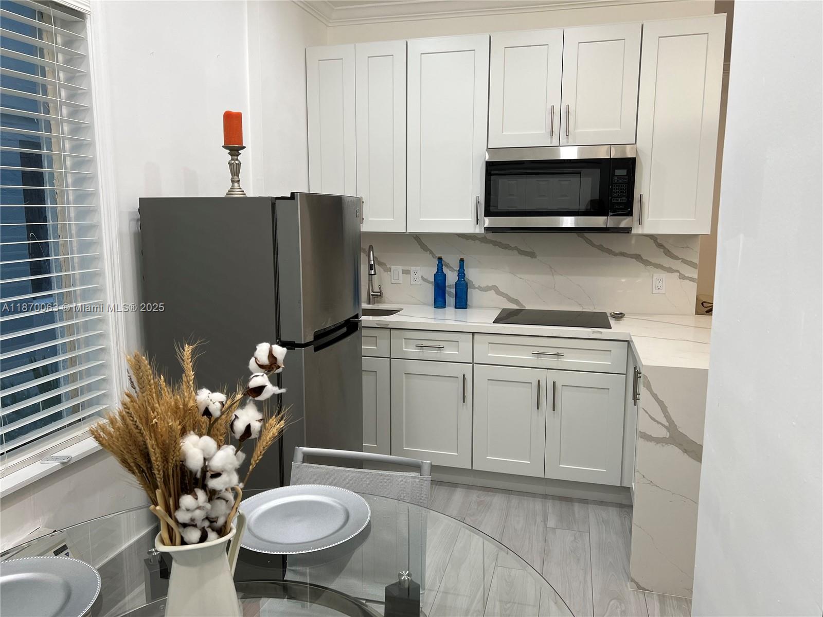 3710 Collins Avenue, Unit N103 Miami Beach, FL 33140 - Photo 18 of 53 a kitchen with appliances cabinets and a sink